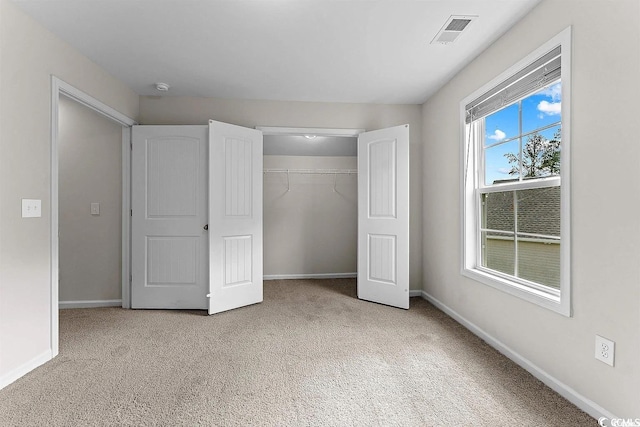 unfurnished bedroom with light carpet and a closet