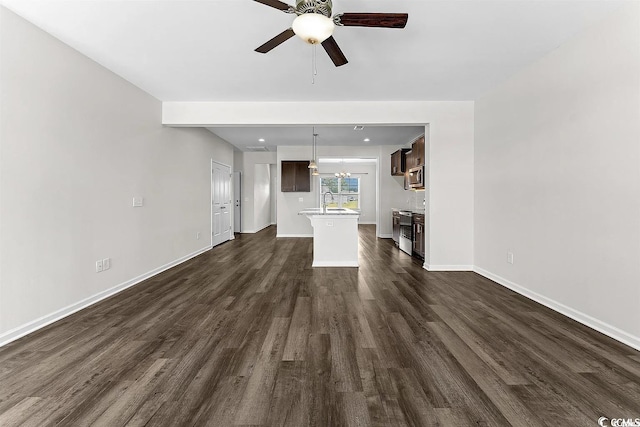 unfurnished living room with dark hardwood / wood-style floors, ceiling fan, and sink