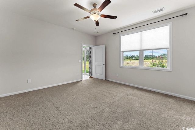 carpeted spare room featuring ceiling fan