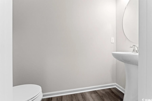 bathroom featuring wood-type flooring, toilet, and sink