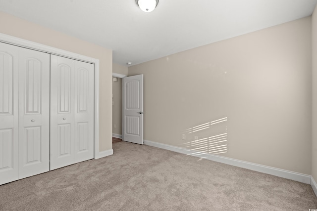 unfurnished bedroom featuring light colored carpet and a closet