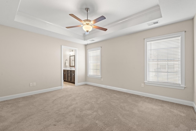 unfurnished room featuring light colored carpet, crown molding, and a tray ceiling