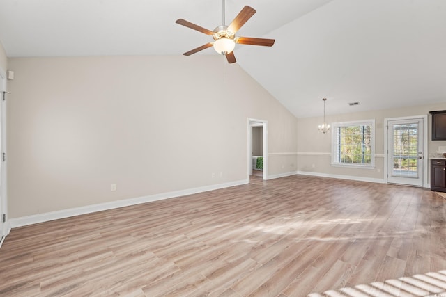 unfurnished living room featuring ceiling fan with notable chandelier, light hardwood / wood-style floors, and lofted ceiling