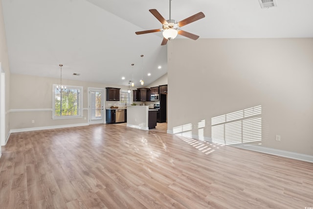 unfurnished living room with ceiling fan with notable chandelier, high vaulted ceiling, and light hardwood / wood-style flooring