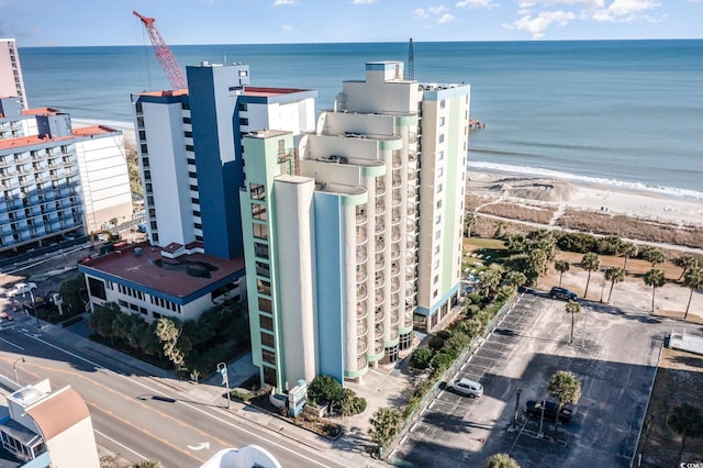 birds eye view of property featuring a water view and a beach view