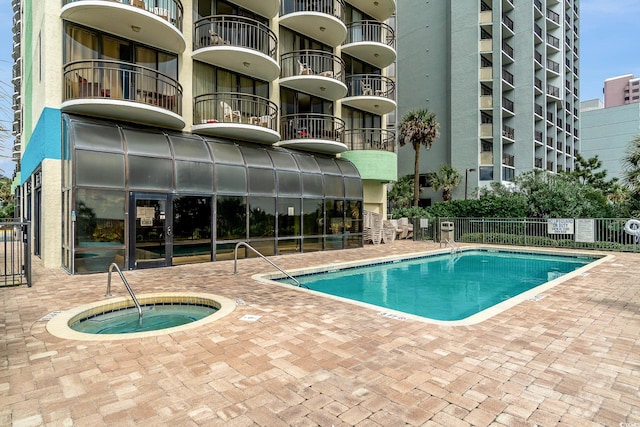 view of pool featuring a community hot tub and a patio