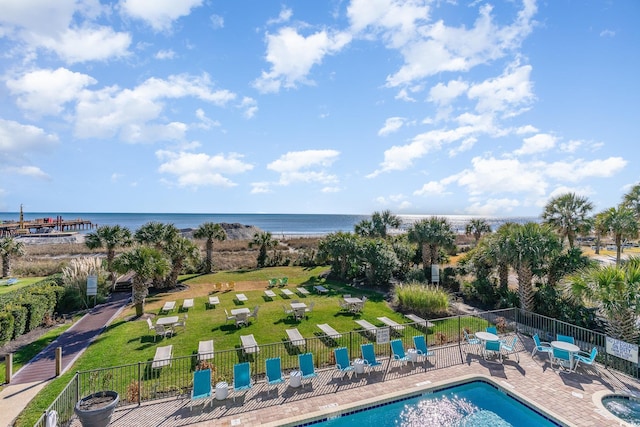 view of swimming pool with a water view, a patio area, and a lawn