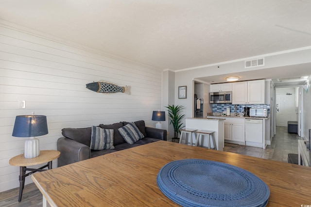 dining space with wooden walls and light hardwood / wood-style flooring