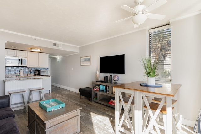 living room featuring hardwood / wood-style floors, ceiling fan, and ornamental molding