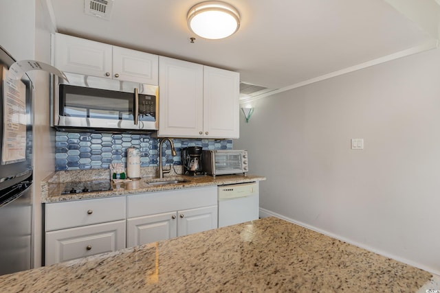 kitchen with white cabinets, light stone counters, sink, and stainless steel appliances