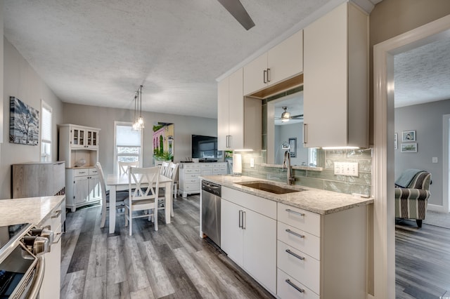 kitchen with tasteful backsplash, a textured ceiling, stainless steel appliances, sink, and pendant lighting