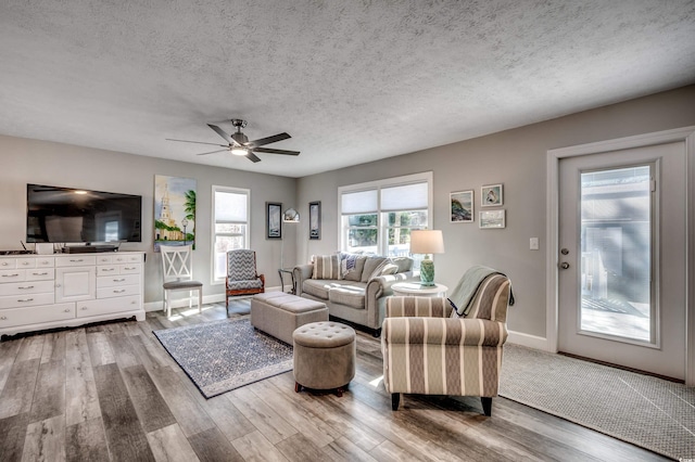 living room featuring a textured ceiling, hardwood / wood-style flooring, and ceiling fan