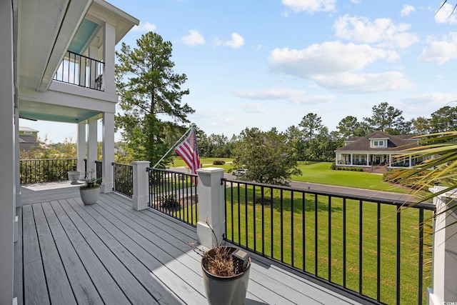 wooden terrace with a lawn and a porch