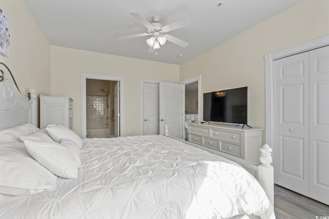 bedroom with ceiling fan, light wood-type flooring, and ensuite bath