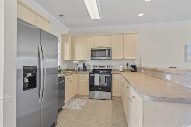 kitchen with light tile patterned floors, ornamental molding, appliances with stainless steel finishes, kitchen peninsula, and cream cabinets