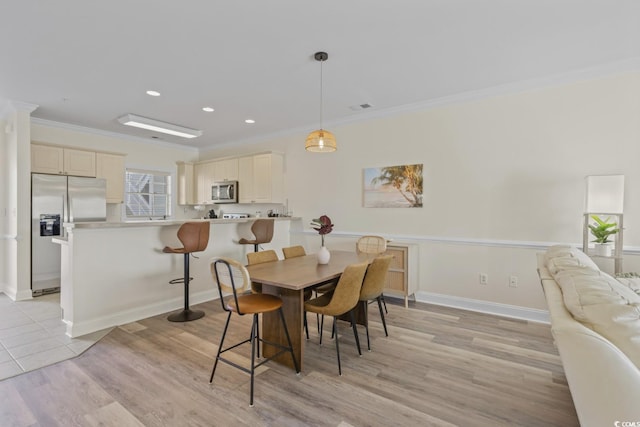 dining room featuring crown molding and light hardwood / wood-style flooring