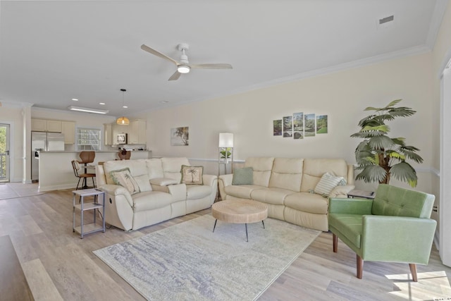 living room featuring crown molding, light hardwood / wood-style flooring, and ceiling fan