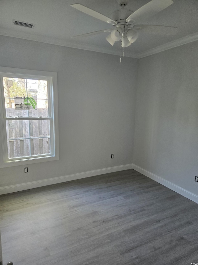 empty room with ceiling fan, crown molding, and hardwood / wood-style flooring