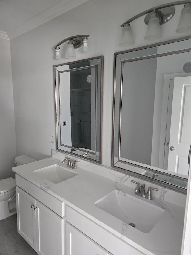 bathroom featuring toilet, crown molding, hardwood / wood-style flooring, and vanity