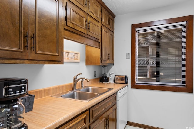 kitchen featuring dishwasher, a textured ceiling, and sink