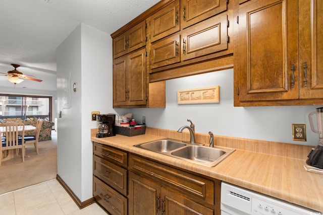 kitchen featuring dishwasher, light tile patterned flooring, ceiling fan, and sink