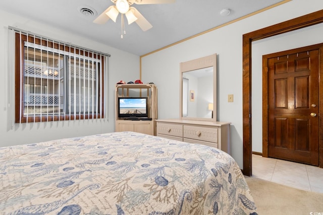 tiled bedroom with ceiling fan and ornamental molding