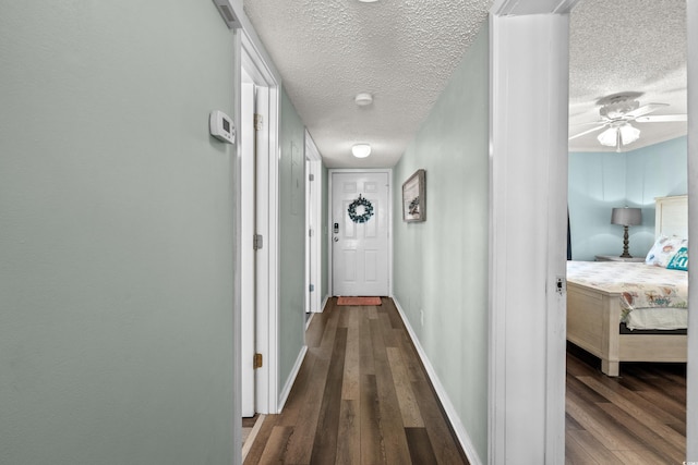 corridor featuring a textured ceiling and dark hardwood / wood-style floors