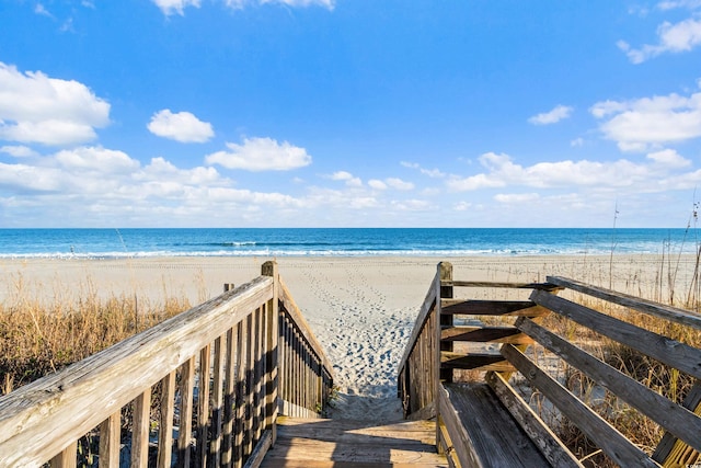 view of home's community with a beach view and a water view