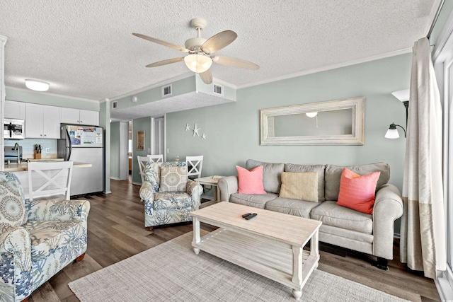 living room with a textured ceiling, ceiling fan, ornamental molding, and sink