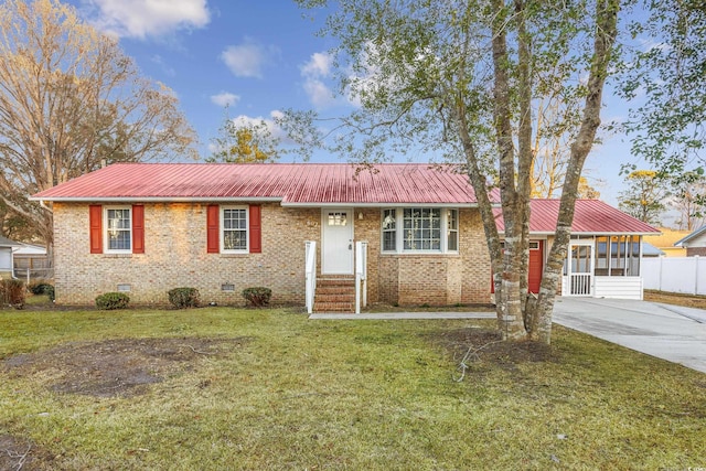 single story home featuring a sunroom and a front lawn