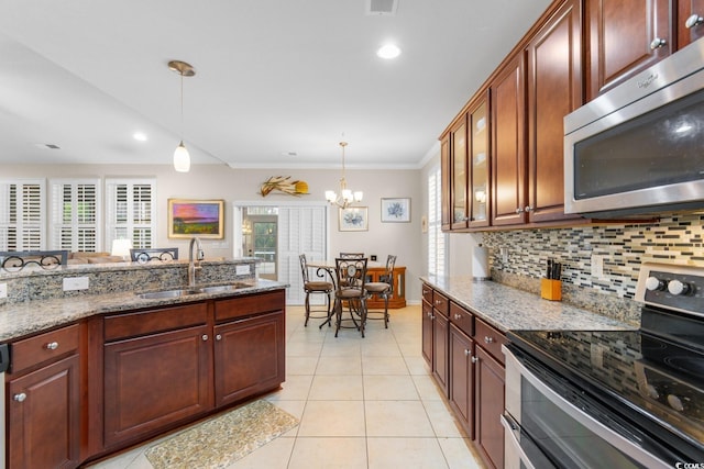 kitchen featuring hanging light fixtures, sink, light stone countertops, appliances with stainless steel finishes, and a chandelier