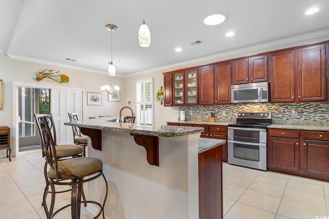 kitchen featuring a kitchen breakfast bar, light stone counters, ornamental molding, and appliances with stainless steel finishes