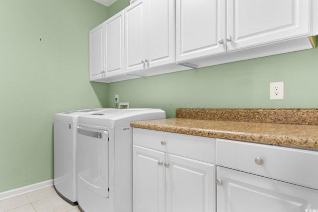 clothes washing area with washer and dryer, light tile patterned floors, and cabinets