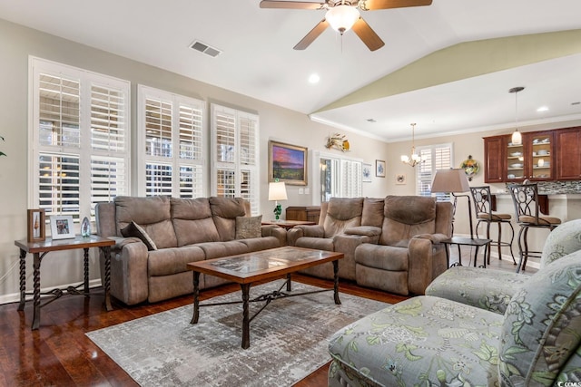 living room with ceiling fan with notable chandelier, dark hardwood / wood-style floors, and lofted ceiling