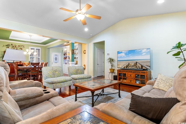 living room featuring hardwood / wood-style floors, ceiling fan with notable chandelier, crown molding, and lofted ceiling