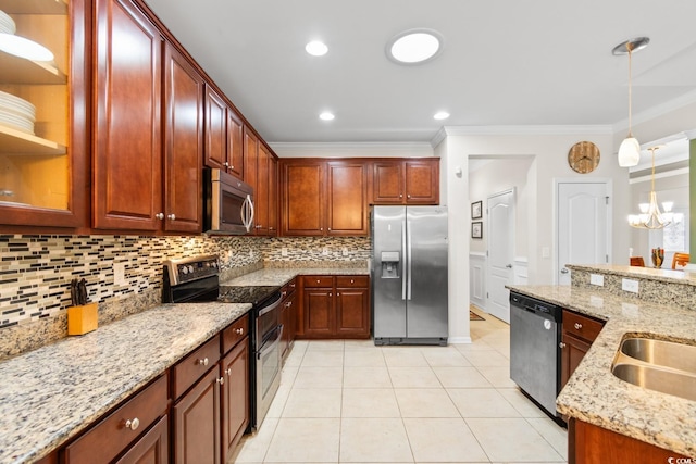 kitchen featuring light stone counters, ornamental molding, stainless steel appliances, pendant lighting, and a chandelier