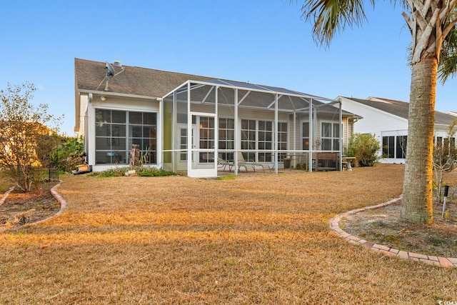 back of property featuring a lawn and glass enclosure