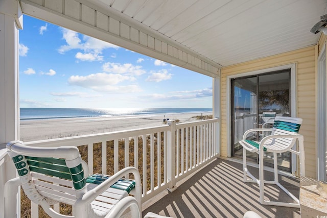 balcony with a water view and a beach view