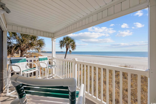 balcony featuring a view of the beach and a water view