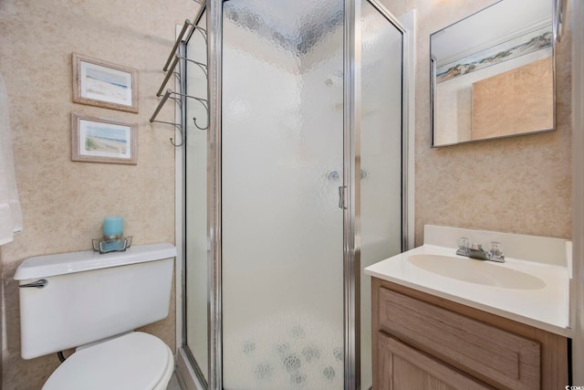 bathroom with walk in shower, vanity, and toilet