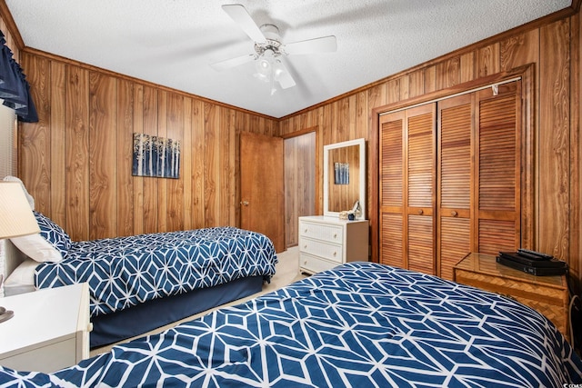 bedroom featuring a textured ceiling, ceiling fan, carpet floors, a closet, and wood walls