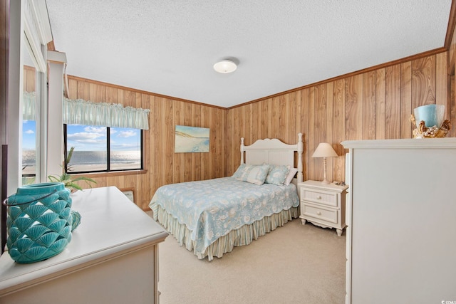 bedroom featuring a textured ceiling, carpet floors, and wood walls