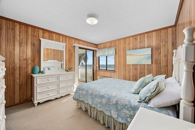 bedroom with access to exterior, a textured ceiling, and carpet floors