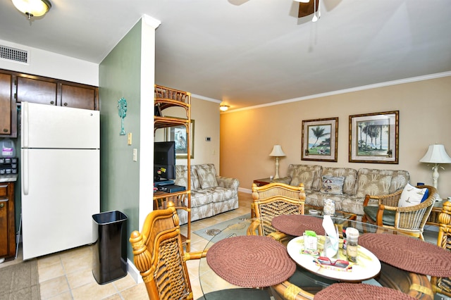 tiled dining space featuring ceiling fan and ornamental molding