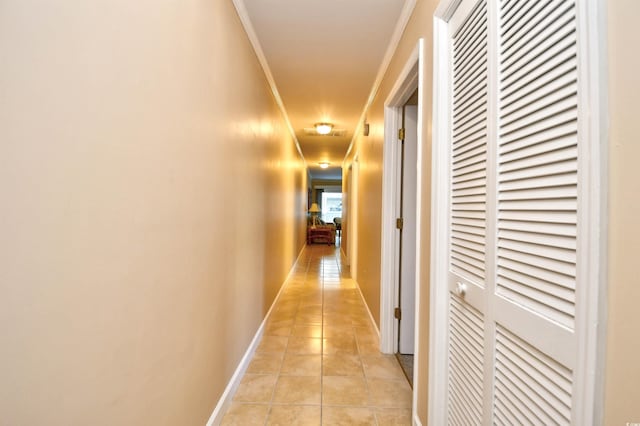 hallway featuring crown molding and light tile patterned flooring