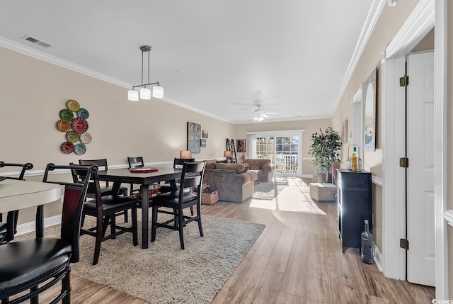 dining space with ceiling fan, ornamental molding, and light hardwood / wood-style floors