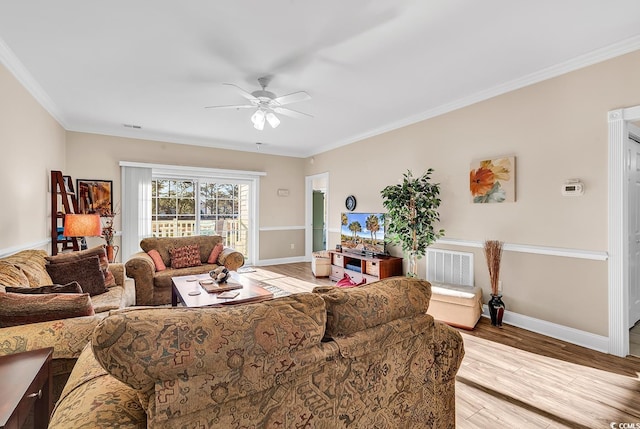 living room with ornamental molding, light hardwood / wood-style floors, and ceiling fan