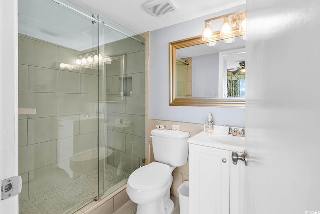 bathroom featuring vanity, toilet, and a shower with door