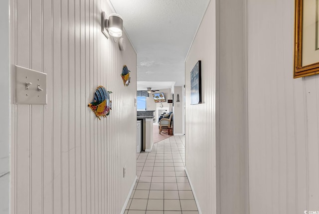 hallway featuring light tile patterned floors and a textured ceiling