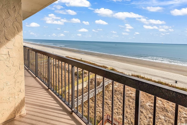 balcony featuring a view of the beach and a water view